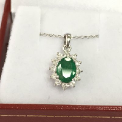An 18ct white gold emerald and diamond pendant on an 18ct white gold chain. Emerald 0.86ct and diamonds 0.37ct.