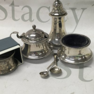 A silver condiment set and a silver napkin.