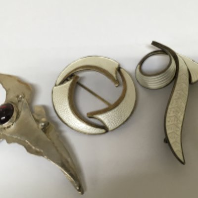 Two silver and enamel modern design brooches and one other silver modern design brooch. (3)