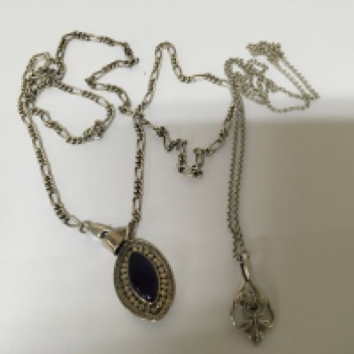 Two Silver necklaces one with a polished amethyst and one other floral pendent both on silver chains. (2)