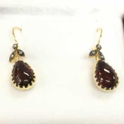 Pair of 9ct yellow gold and silver drop earring set with oval cabochon garnet with rose cut diamonds set to foliate bale with fish hook fitting. Garnet 2.80ct diamonds 0.06ct.
