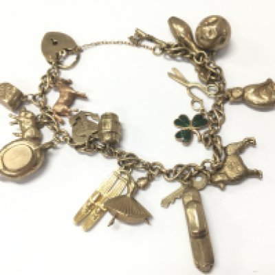 A 9 carat gold charm bracelet. 31.6g total weight. Postage category A