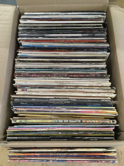 A box of LPs and 12" singles by various artists including Ian Dury, Joni Mitchell, Jethro Tull and others.