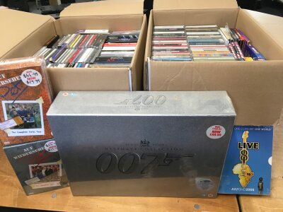 Two boxes of CDs mainly Madonna but also including Abba, Ed Sheeran, Michael Jackson and many more, many sealed. Also includes a sealed 40 disc James Bond DVD set and other sealed DVD box sets.