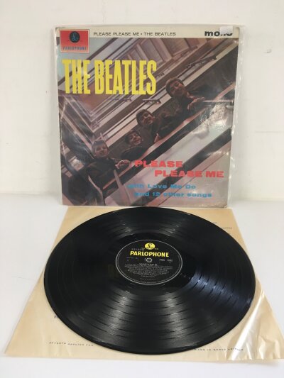 An early UK pressing of The Beatles LP Please Please Me on mono with small 33 1/3 on black and yellow Parlophone labels, XEX 421-1N / 422-1N. Vinyl EX, wear to spindle hole but vinyl is very clean.