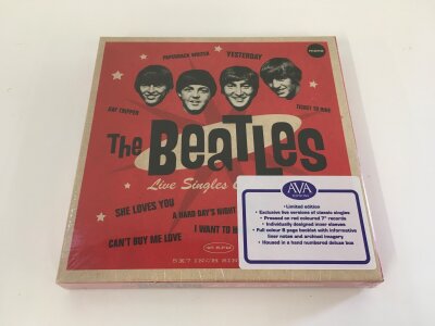 A sealed The Beatles Live Singles Collection 7" box set on red vinyl.