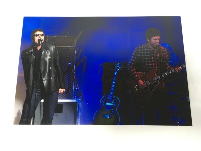 A Liam and Noel Gallagher signed photo, no COA. Approx 30cm x 20cm.