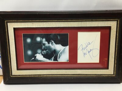 A framed and glazed Freddie Mercury autograph and photo with COA, approx 40cm x 24cm plus a Brian May autograph and photo with UACC registered COA, approx 33cm x 46cm.