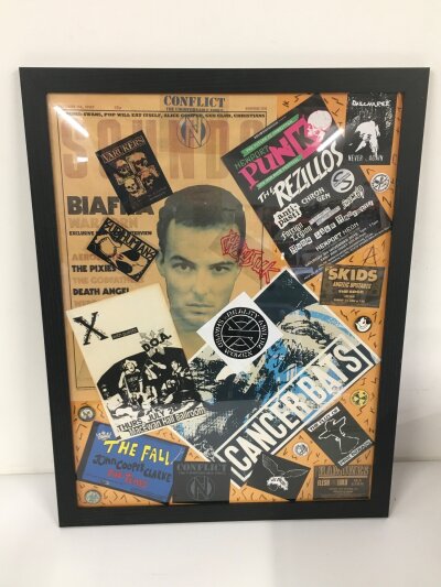 A framed display of punk and indie flyers, stickers, badges etc plus a framed Stranglers Falklands  tour poster from 1997 and various music books including first editions etc.