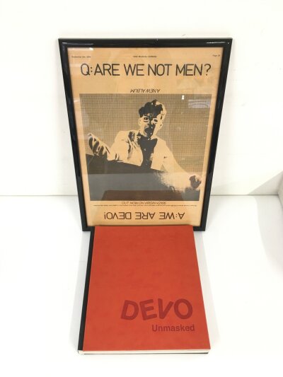 A 2018 hardback two in one book Devo - Unmasked and Devo - The Brand plus a framed 1978  NME full page advert for the Are We Not Men? LP (2).