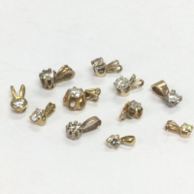 Eleven gold solitaire diamond pendants, total approx 5g. Shipping category A.