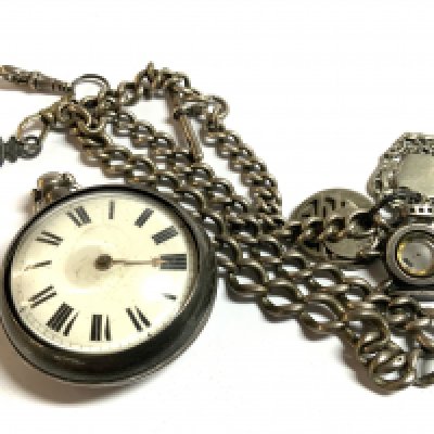A heavy hallmarked silver Albert chain with a pair cased silver pocket watch and charms. (D)