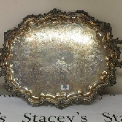 A large silver plated tray with a shaped edge and carrying handles diameter 75cm