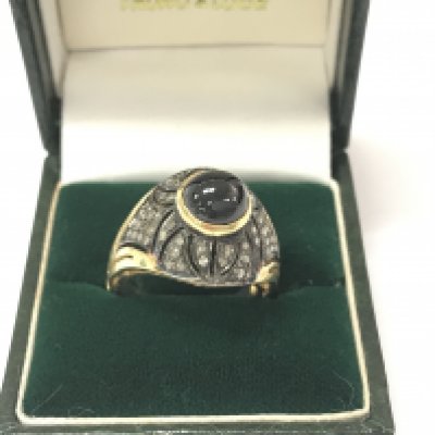 A silver gilt ring rubover set with a cabochon sapphire and several rose cut diamonds. Sapphire 3.58ct and diamonds 0.41ct. Size N