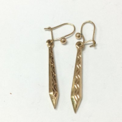 A pair of gold tone drop earrings.