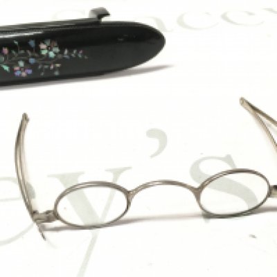 A pair of silver spectacles in a case.