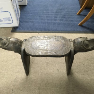 A hand carved African stool. Length 90cm, height 43cm.