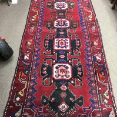 A Persian wool rug. Approx measurements 295x109cm.