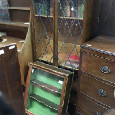A Cole toon of furniture comprising two oak bookcases, a hanging display cabinet, a folding card table and a mahogany jardiniere stand