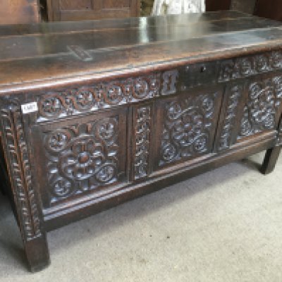 A large oak blanket box, the hinged lid above a carved panel front. 58cm x 140cm x 75 cm