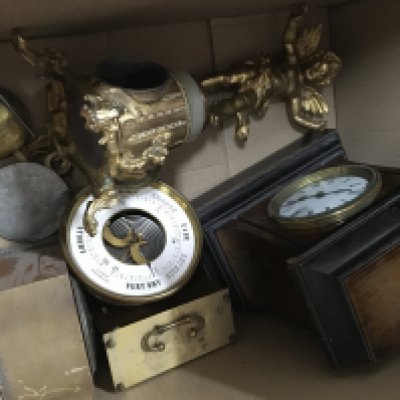 A box containing a collection of clocks and a barometer