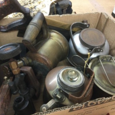 A box containing vintage tools and cans