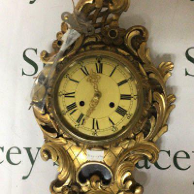 A Gilt wood Gesso wall clock of Rocco design with folate scrolls. With pendulum and key. 58cm- NO RESERVE