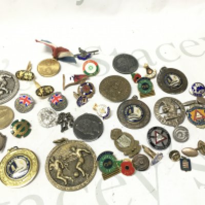 A collection of badges including commemorative pins, poppy pins, cap badges . Postage category a