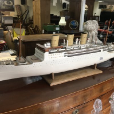 A model of a three funnel steam ship on a wooden base support