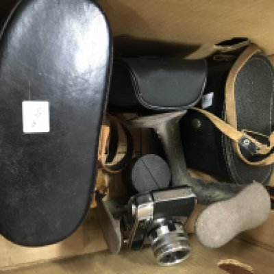 A box containing a camera and two pairs of binoculars