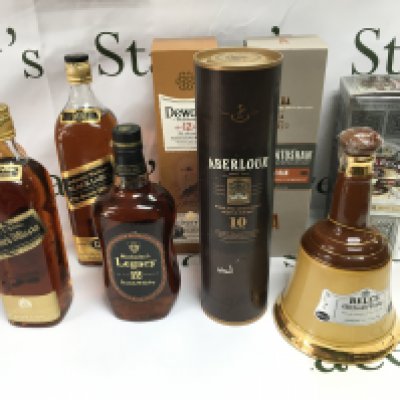 A collection of 9 bottles of various whiskey including Dewars Johnnie Walker bells etc