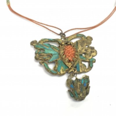 A coral necklace with a butterfly style brass pendant