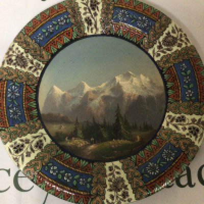 A quality ceramic Continental wall plaque hand painted with Tyrollean view with snow caped mountains and figures signed and with makers name to the reverse no obvious damage. 39cm wide.- NO RESERVE
