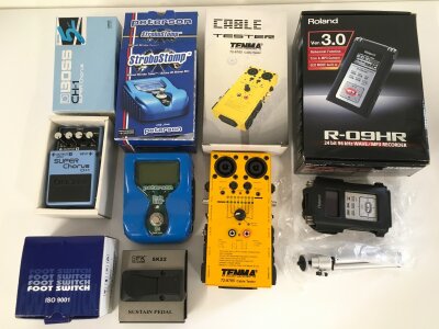 A collection of boxed guitar pedals comprising a Boss CH-1 Super Chorus, a Peterson Strobo Stomp, a Soundking Sustain pedal plus a Roland R-09HR MP3 recorder and a Tenma cable tester.