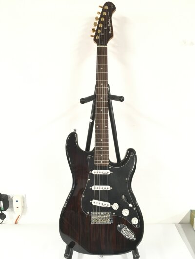A Harley Benton Deluxe Series Stratocaster style electric guitar with a rosewood style finish. Comes with a soft carry case.