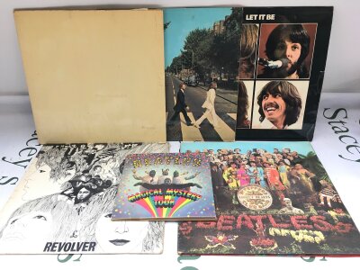 Five early UK pressings of Beatles LPs comprising a numbered White Album (missing two portraits and poster damaged), Abbey Road, Revolver and others plus a Magical Mystery Tour EP. Some feelable scratches and sleeve wear.