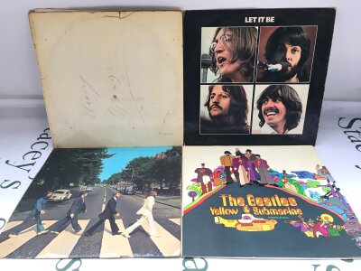 Four Beatles LPs comprising an early numbered pressing of the White Album 0001726 (poster but no portraits, various pen marks on cover, ringwear, feelable scratches on vinyl), together with early pressings of Let It Be, Abbey Road and Yellow Submarine.