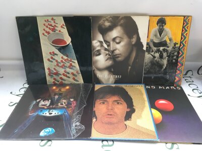 Two bags containing twelve Paul McCartney and Wings LPs comprising Ram, Press To Play, McCartney II and others.