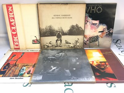 Two bags containing 12 LPs by various artists comprising Eric Clapton, George Harrison, The Who and others.