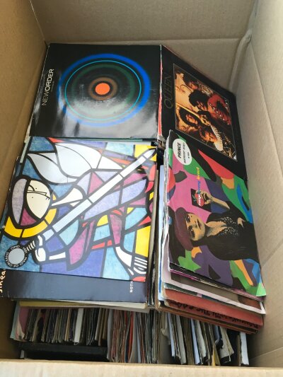 A box of 7" singles by various artists including Morrissey, Prince, Queen and many more.