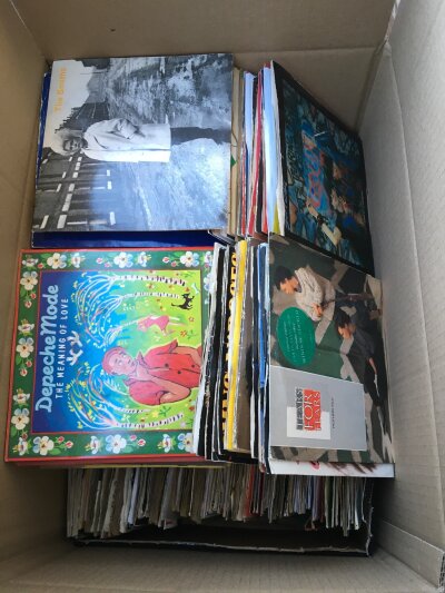 A box of 7" singles by various artists including The Smiths, Depeche Mode, New Order and many more.