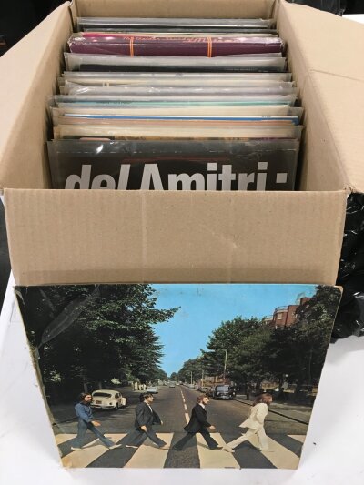 A box of LPs and 12" singles by various artists including The Beatles, Elvis Presley, various movie soundtracks etc.