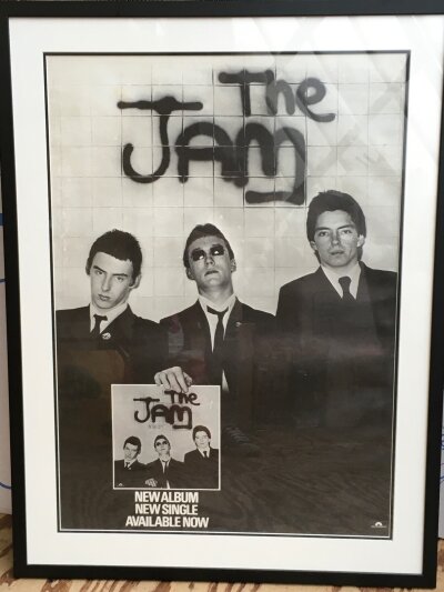 A framed and glazed poster for The Jam's debut album and single, approx 64cm x 84cm.