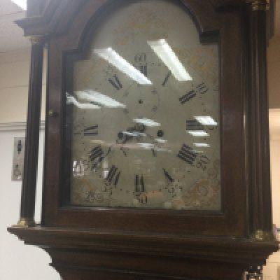 A mahogany long case the painted dial with Roman numerals.