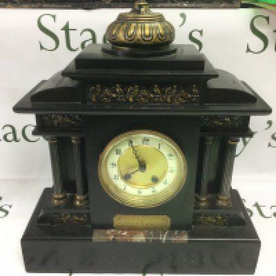 A slate mantle clock with decorative panels and Corinthian column supports. Shipping category D. NO RESERVE A