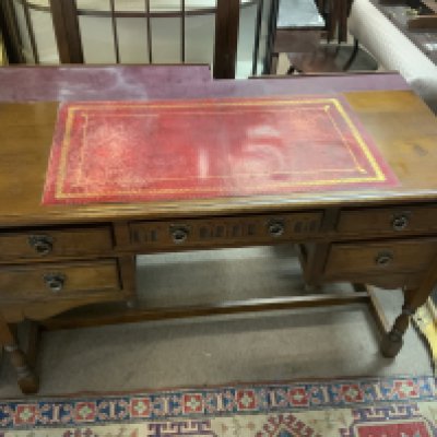 An oak linen fold design leather topped desk, with later fitting to the back. W 127cm x H.77cm