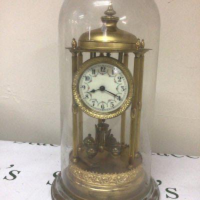 A vintage clock with six pillars an anniversary clock under a glass dome seen working. Height 45cm heigh.