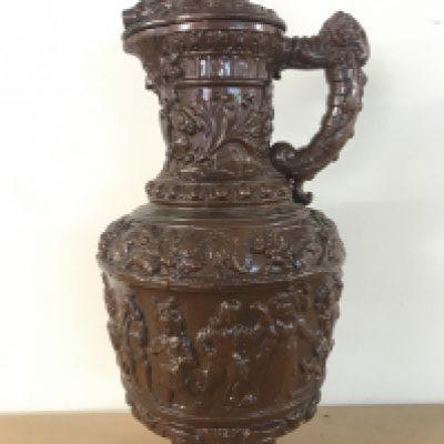 A German pottery ewer, Metilach style decorated with classical style figures and animals. 53cm tall approximately .This lot cannot be posted