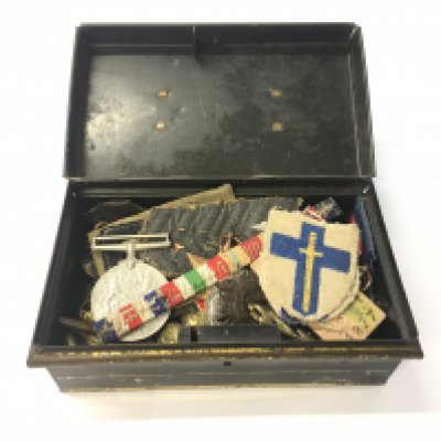 A boxed collection of a variety of World War Two badges, medals and buttons.