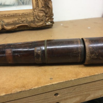 A three draw brass telescope with leather case .